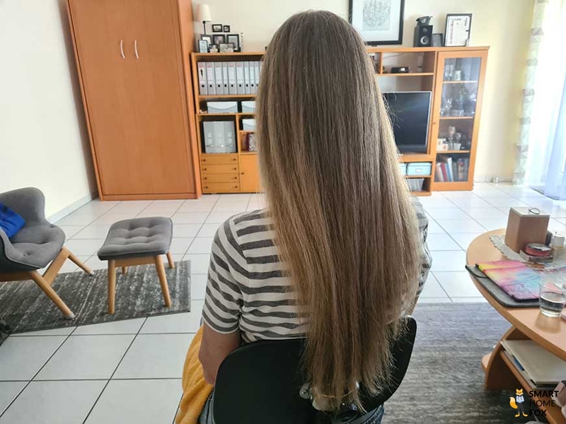 Длинные волосы выпрямлены с помощью стайлера Дайсон Airwrap.